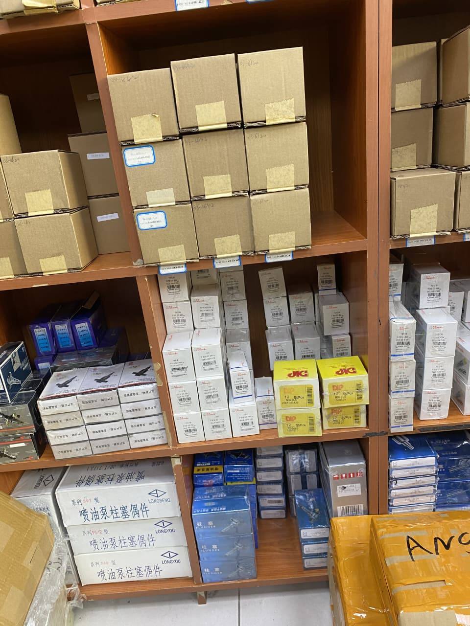 Shelves of genuine replacement components — nozzles, plungers, and injector parts